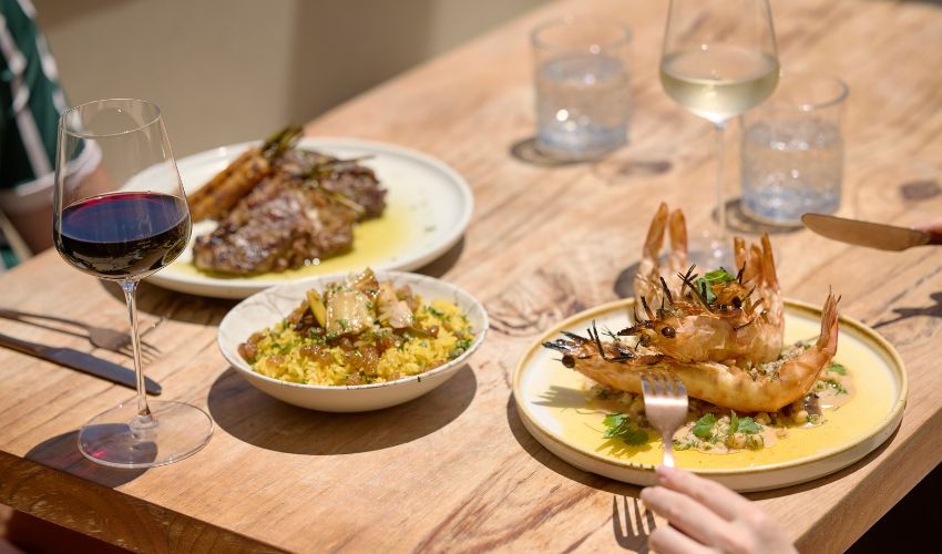 Shared seafood dishes and wine served on a table at Blanca.
