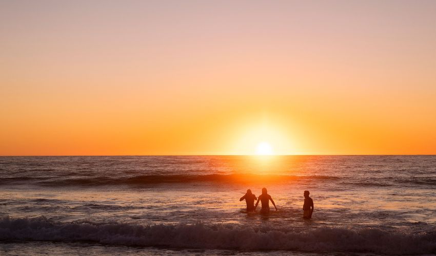 Friends enjoying a sunset swim at Merewether Beach.