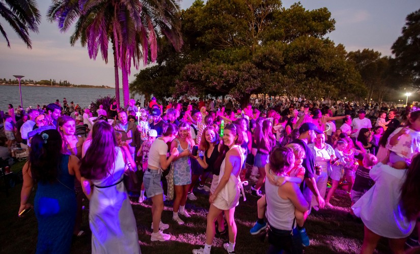 Crowd gathered near Newcastle Harbour for New Year's Eve under a purple light